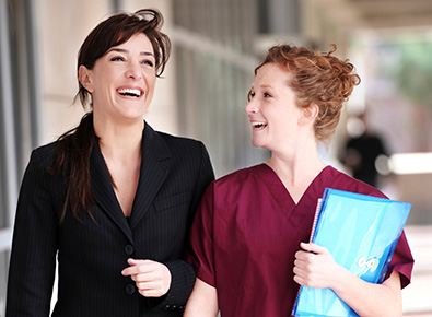 Photo of a nurse and another staff member talking and walking.